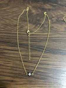 Detail of gold evil eye necklace with lobster clasp and adjustable extension chain