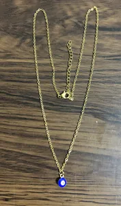 Detail of gold evil eye pendant with adjustable lobster clasp and fine link chain