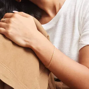 Detail of 18K gold plated bead chain and minimalist finger ring on female model wrist