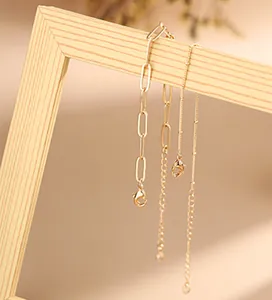 Detail of golden paperclip chain bracelet with bead accents and lobster clasp
