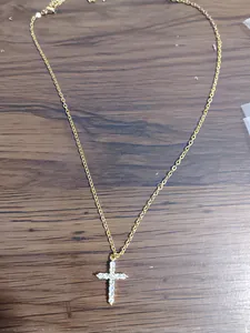 Detail of gold-plated cross pendant with cubic zirconia and lobster clasp closure