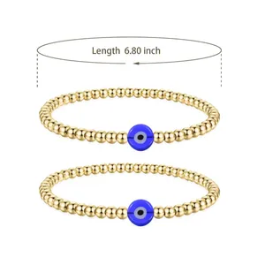 Detail view of 6.80 inch golden bead stretch bracelets with blue evil eye charms