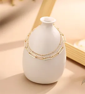 Close-up of double-layered 18K gold stainless steel bead and paperclip chain bracelet