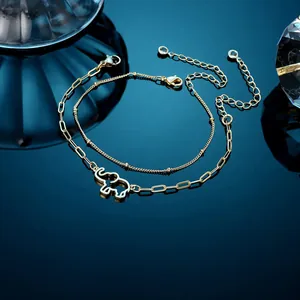 Detail of 18K gold double-layer chain bracelet featuring a hollow elephant pendant