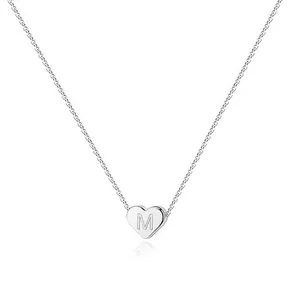 Macro detail of silver heart pendant with engraved letter M on a stainless steel chain