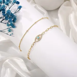 Detail of gold evil eye bracelet with tiny diamonds and a fine beaded chain set
