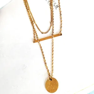 Dettaglio della collana multistrato placcata oro 18K con pendenti a barra e disco rotondo