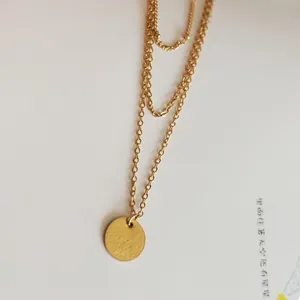 Detail of double-layer gold plated stainless steel necklace with round disc pendant