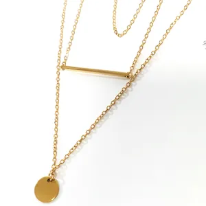 Detail of layered gold stainless steel necklace with bar and round disc pendants
