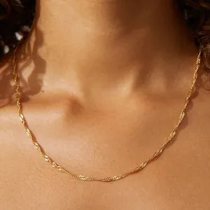 Minimalist 18K gold-plated stainless steel water wave chain necklace worn by a model