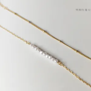 Close-up of double-layered 18K gold-plated stainless steel bracelet with freshwater pearls