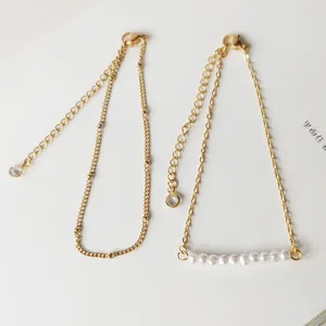 Detail of 18K gold-plated stainless steel chain with layered pearls and zircon drop