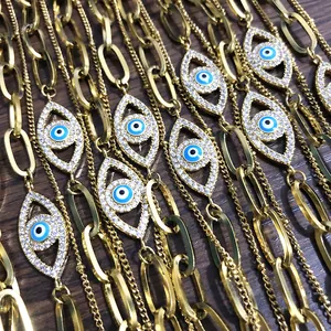 Gouden paperclip ketting armband met een blauwe boze oog bedel en glanzende zirkoniasteentjes