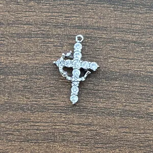 Macro view of brass cross pendant with 3A cubic zirconia in 18K gold plating on wood