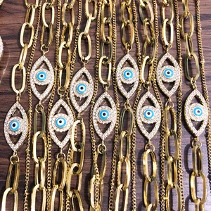 Detail van 18K vergulde evil eye bedeltjes met blauwe stenen op gelaagde parelkettingen