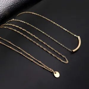 Layered gold-plated necklace set with curved tube and star pendants on black background