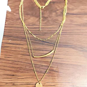Three-layer gold-plated layered necklace featuring a sleek curved tube and coin pendant