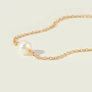 Detail van de 18K vergulde paperclipketting met een witte parel en hanger voor dames