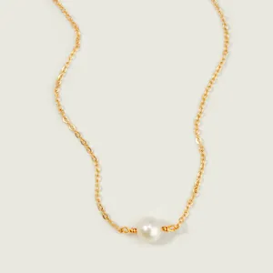 Detailopname van de vergulde ketting met een witte parel en handgemaakte draadafwerking