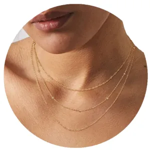 Three-layer gold stainless steel necklace with delicate bead details on a layered chain