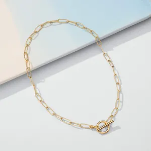 Detail of 18K gold paperclip chain necklace featuring a modern toggle clasp closure