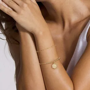 Detail van 18K vergulde dubbellaagse armband met zirkoon hexagon letter A hanger