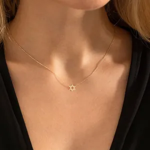Detail van een gouden Davidster-hanger aan een fijne roestvrijstalen schakelketting