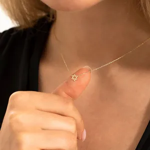 Detailopname van de gouden Davidster hanger aan een fijne roestvrijstalen schakelketting