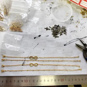 18K gold-plated infinity symbol bracelets with charms and assembly parts on white background