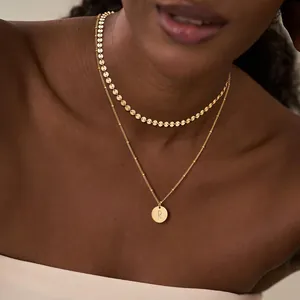 Detalle del conjunto de collares dobles chapados en oro 18K con colgante de letra R