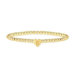Detailed close-up of gold beaded bracelet featuring a heart pendant with the letter B