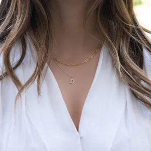 Detail view of double-layered paperclip chain with crystal-encrusted letter D pendant