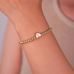 Detail of 18K gold-plated beaded bracelet with heart charm and engraved letter D