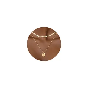 Detalle de collar de doble capa bañado en oro de 18K con colgante redondo de letra J