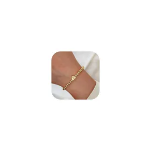 Macro shot of gold-plated beaded bracelet with a polished heart charm featuring letter K