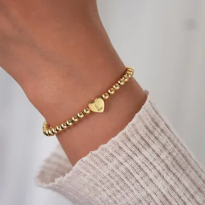 Detail of 18K gold-plated beaded bracelet featuring a heart pendant with letter L