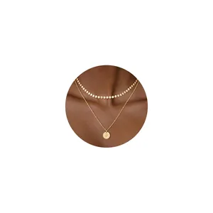 Detalle de collar de doble capa de oro de 18K con cadena de lentejuelas y colgante letra P