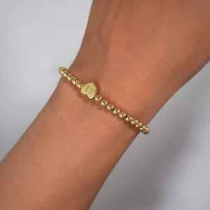 Macro view of 18K gold-plated beaded bracelet featuring a heart-shaped letter N charm