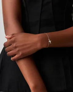 Close-up of 18K silver double-layer cross bracelet with cubic zirconia on a wrist