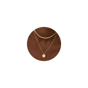 Detalle del collar de doble capa chapado en oro de 18K con colgante de letra R en un modelo
