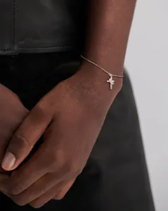 Detailed view of silver cross bracelet with sparkling crystals on a female wrist