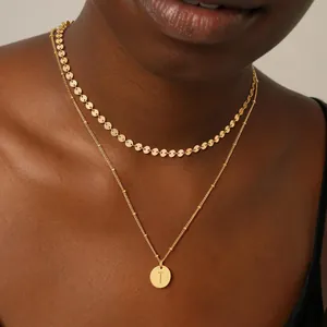 Detalle del collar de doble capa bañado en oro de 18K con colgante de letra T