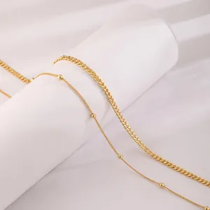 Detail of 18K gold-plated double-layer body chain with curb and satellite bead link