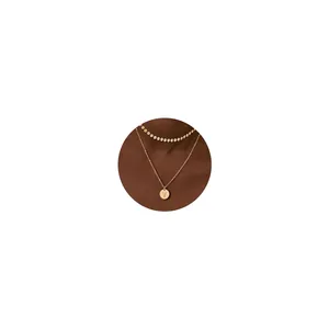 Detalle de collar de doble capa de oro 18K con cadena de discos y colgante redondo letra V