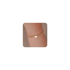 Detail of 18K gold-plated beaded bracelet with a heart charm featuring letter Q engraving