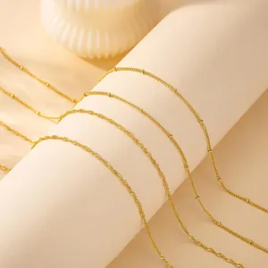 Detailed view of layered 18K gold plated stainless steel wave and satellite bead chains