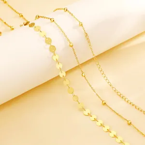 Detail of 18K gold plated multi-layer chain jewelry featuring beads and round disks