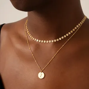 Detalle de collar de doble capa bañado en oro de 18K con colgante redondo y letra Z
