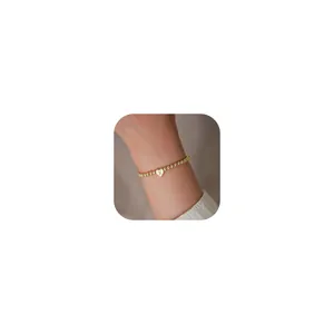 Detail of 18K gold plated bead bracelet with heart charm featuring engraved letter X
