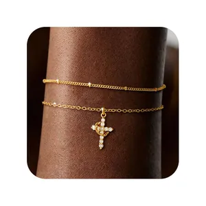 Detail of 18K gold double-layer chain bracelet featuring a zircon-encrusted cross charm